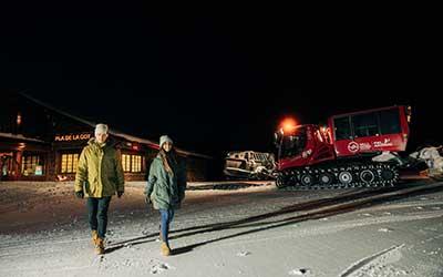 Dos personas saliendo de una cena de alta montaña en Pal Arinsal en Febrero